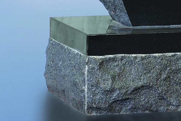 The top of the base along with a 1.5 inch margin along the top is polished; the balance has a rock pitch finish. (Craig p. 6)